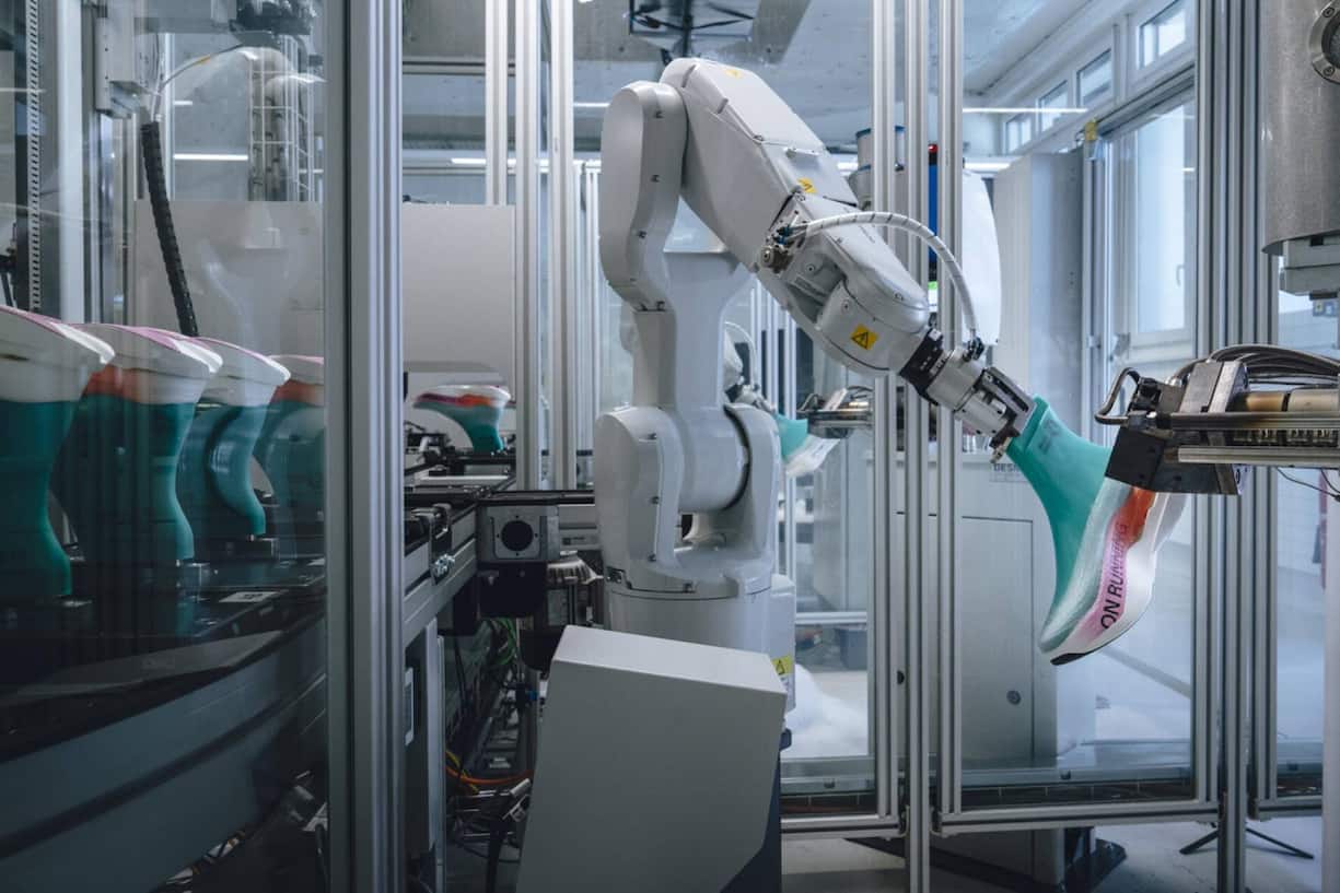 Der Roboter sprüht den Schuh auf den Leisten (in Türkis).