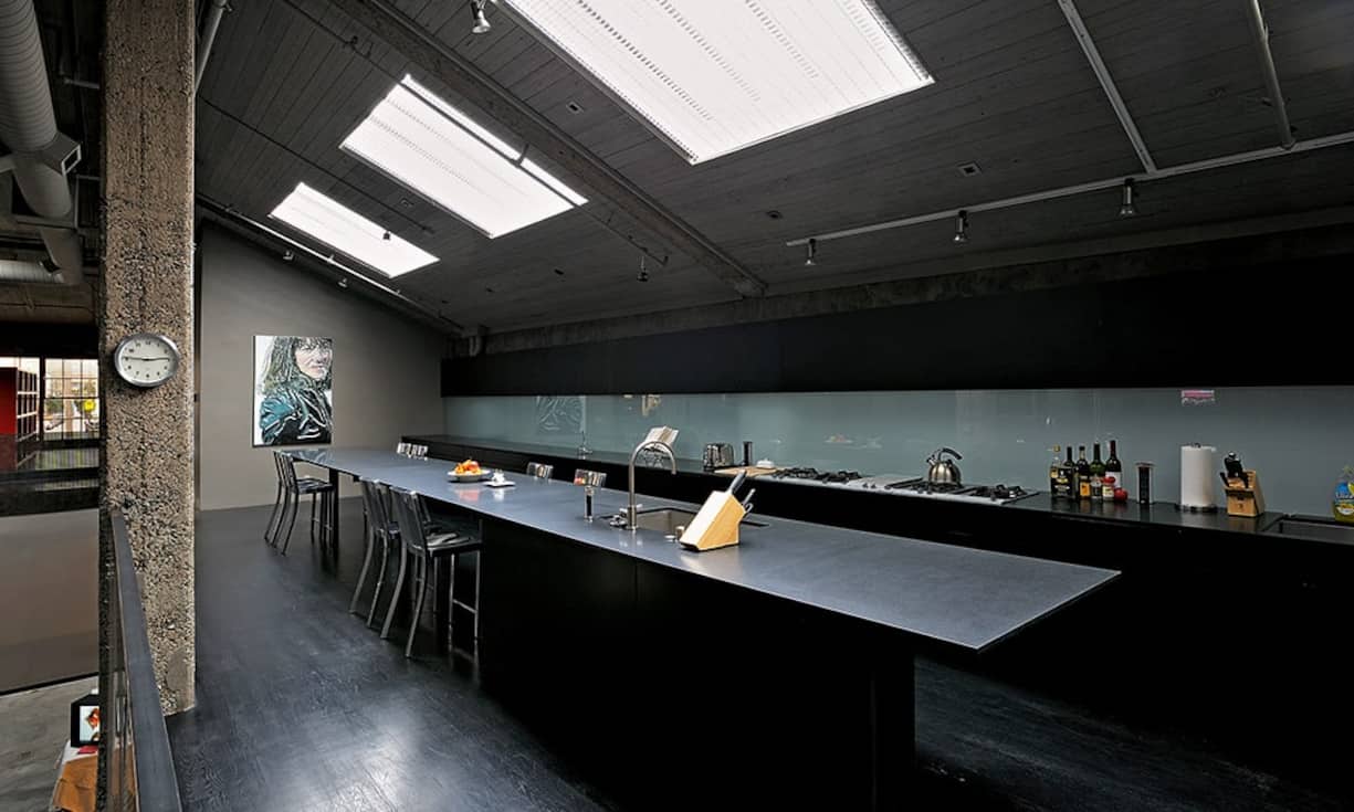 Die Gaggenau-Küche erhält nonkonformistischen Charme durch den Einbau einer zwölf Meter langen Kochinsel, die gleichzeitig als Tisch dient. Die originalen Oberlichter durchfluten die Räume
mit viel Tageslicht.