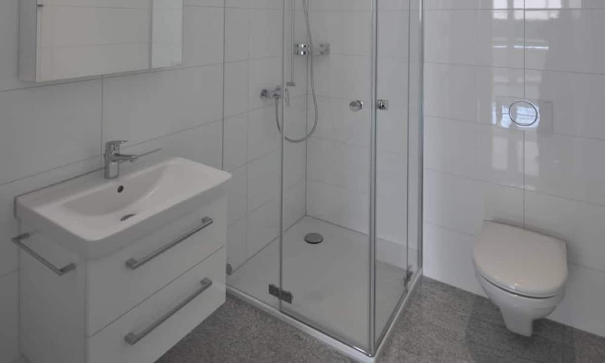 Badewanne und Waschküche sind im grösseren Badezimmer zu finden. Die Innenräume wurden in Weiss gehalten und die Böden mit hellgrauem Granit ausgelegt. Die Wohnung hat vier geräumige Zimmer.