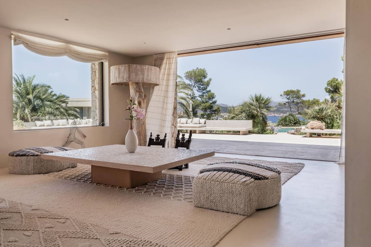 Blick aus dem Wohnzimmer mit grossen Fenstern und weit öffnenden Terrassentüren.