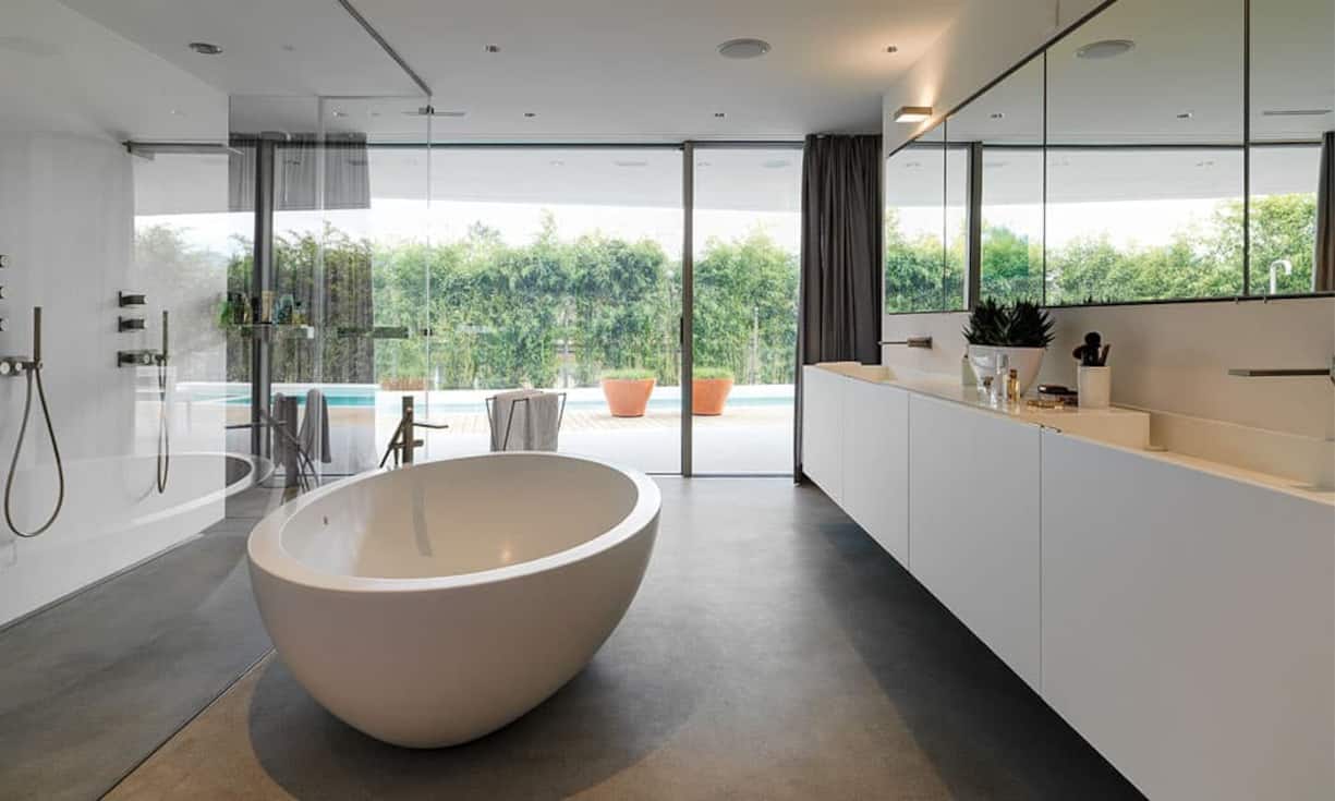 Erlesen: Glas, weisse Flächen, hochwertige Armaturen (Fantini), die Wanne (Boffi) und Mass-Einbauten schaffen ein edles Ambiente.