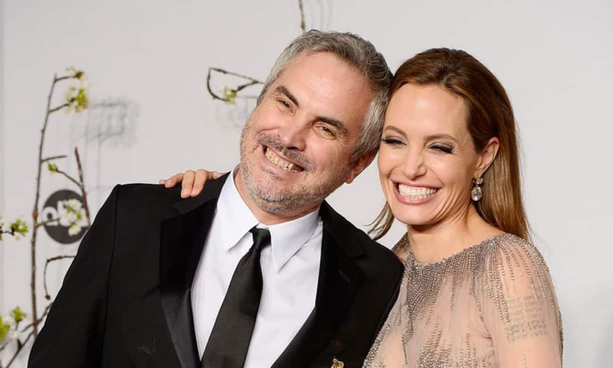 Der mexikanische Direktor Alfonso Cuaron hält seinen Oscar für den Film «Gravity» in den Händen. Daneben strahlt Angelina Jolie mit ihm um die Wette.