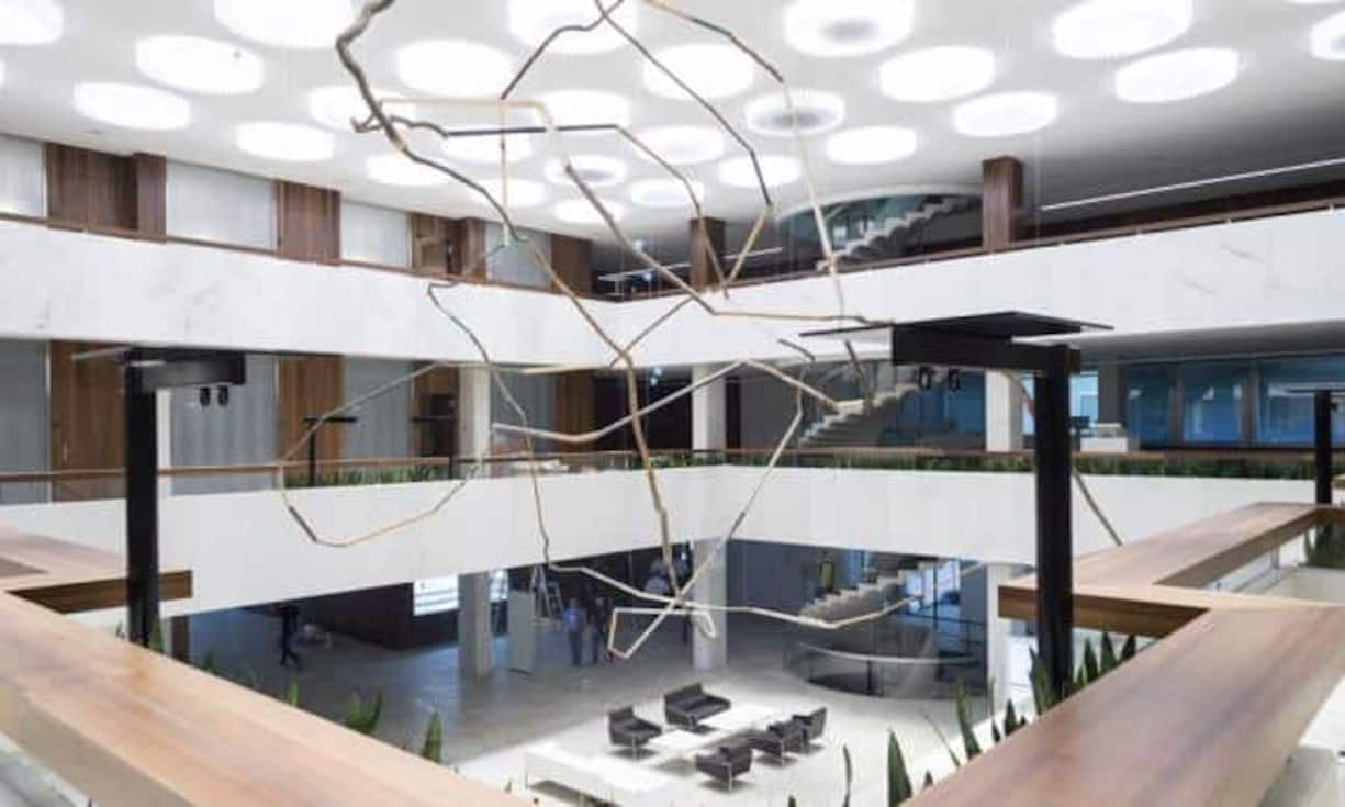 Über drei Stockwerke schwebt ein leichtes Holzkunstwerk, das eine Endlosschleife darstellen soll.