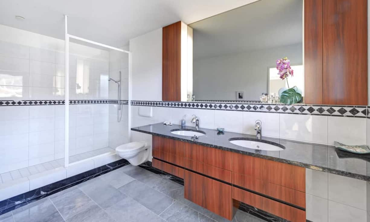 Das geräumige Bad ist mit erlesenen Materialien wie beispielsweise dem Waschtisch aus Granit ausgestattet.