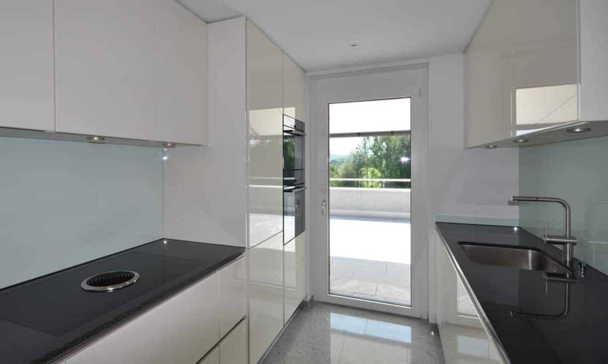 ...in der Küche. Die Liegenschaft befindet sich in der Nähe zum Zugersee und Golfplatz. Das Bergpanorama und der Blick auf den See sind von der Terrasse möglich.