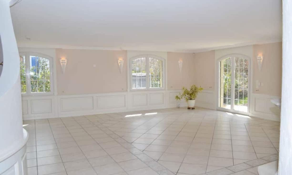 Das Wohnzimmer mit beinahe 70 Quadratmetern bietet genügend Platz um sich individuell einzurichten. Das integrierte Cheminée bringt Wärme in den in hellen Farbtönen gehaltenen Wohnraum.