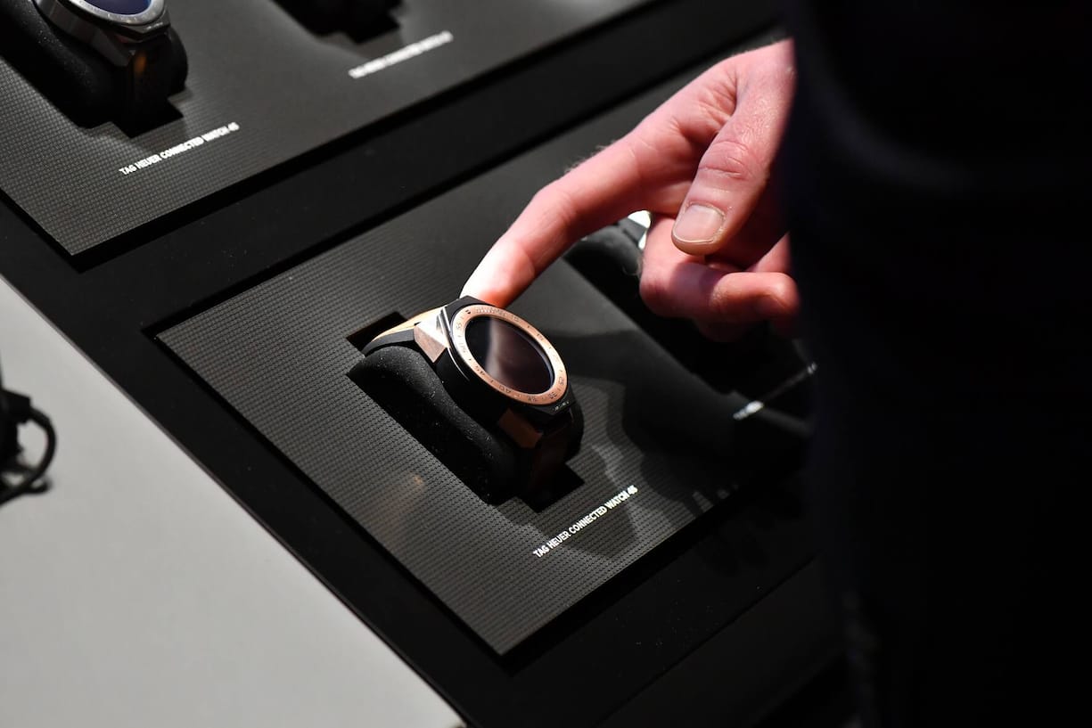 BASEL, SWITZERLAND - MARCH 23:  A visitor points a TAG Heuer Connected Watch 45 displayed at the BaselWolrd watch fair on March 23, 2018 in Basel, Switzerland. The annual watch trade fair sees the very latest horological designs unveiled from companies from all over the world.  (Photo by Harold Cunningham/Getty Images)