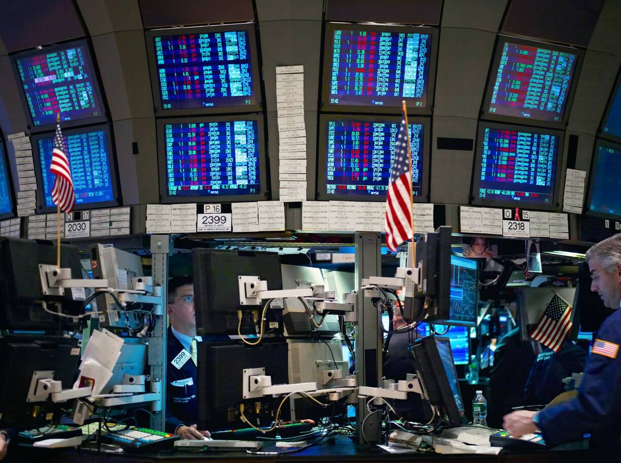 Traders work in front of computers on the floor of the New York Stock Exchange.