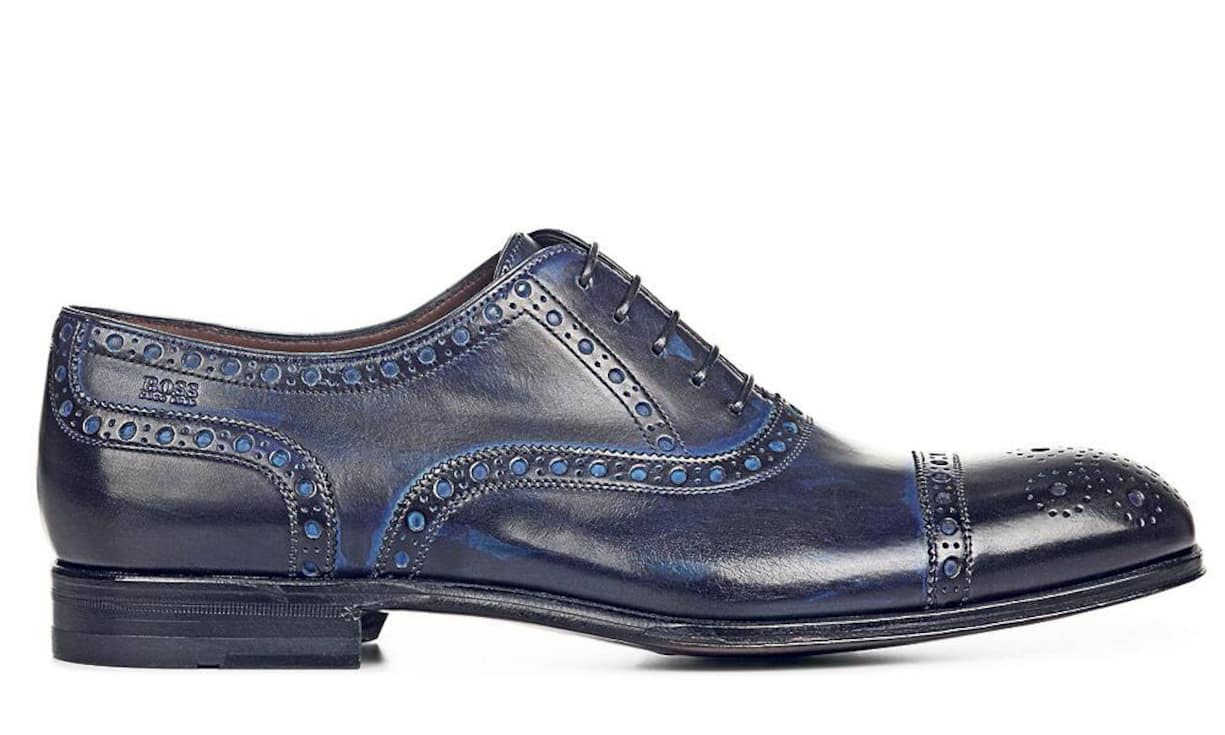 Boss Budapester: Das changierende Farbenspiel des Herrenschuhs von Boss ist eine willkommene Abwechslung im Einerlei der Geschäftsschuhe in Schwarz und Braun. Dieser typische Budapester mit gestanzten Lochmustern ist modisch und klassisch zugleich. Modell «Capetis», Preis: 549 Franken