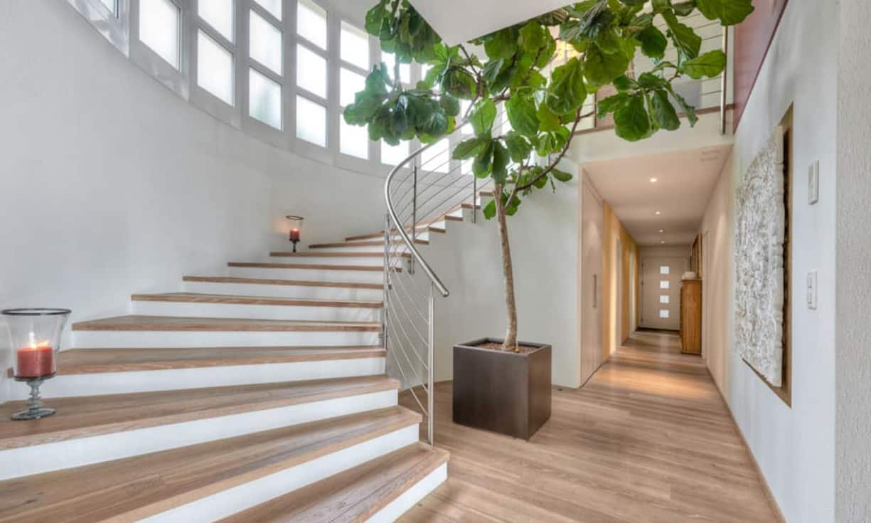 Über eine halbrunde, grosse, offene Treppe gelangt man in den hellen Wohn-/Essbereich mit Kochinsel.