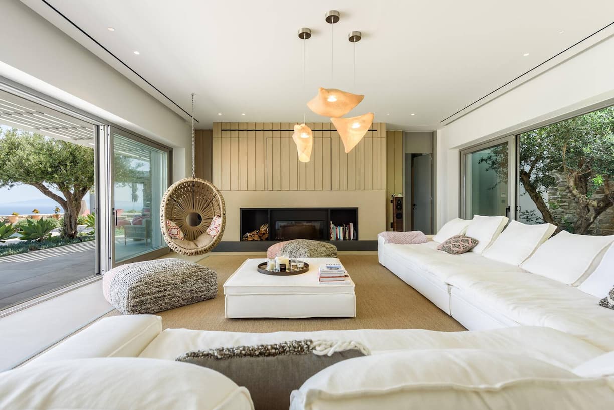 Die Sofalandschaft im Wohnzimmer ist von Fabbrica aus Athen. Den Hängesessel, die Poufs und die kuscheligen Kissen fand man bei lokalen Händlern in Paros.