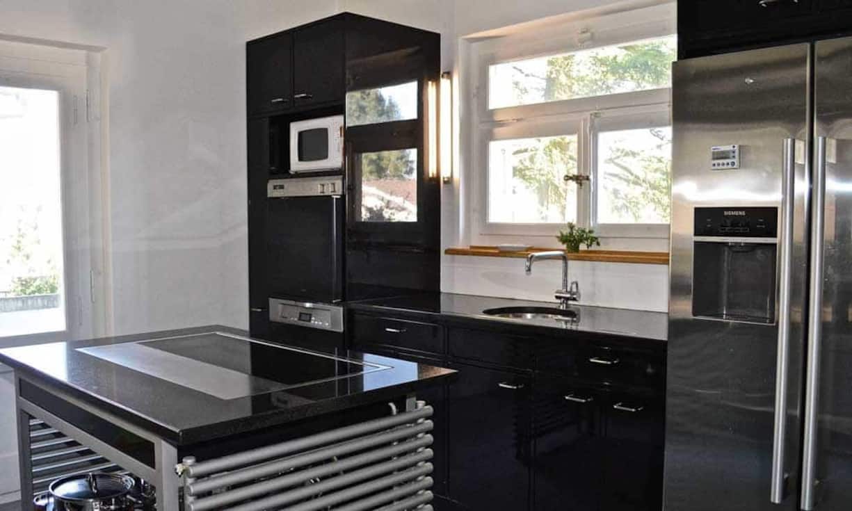 Die moderne, geschlossene Küche hat einen eigenen Balkonzugang.