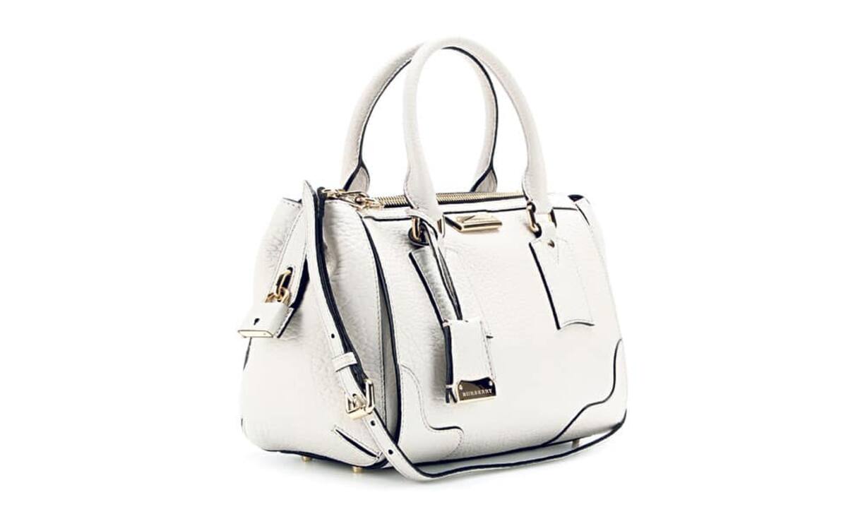 Ein raffinierter Farbkontrast prägt die Gladstone- Henkeltasche von Burberry. Das fein genarbte Leder im Vintage-Look und die goldenen Details lassen sie edel wirken. Preis: 1.495 Franken mytheresa