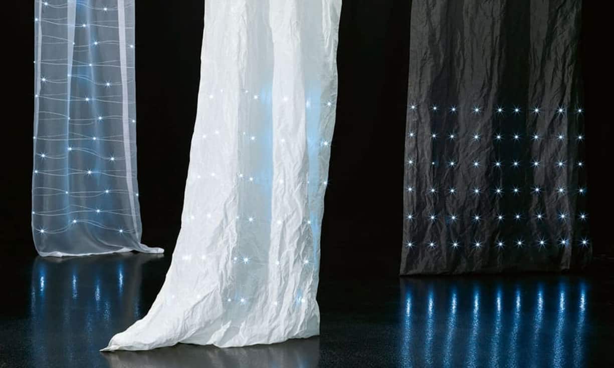 Himmlisch: Der Schweizer Textilspezialist Création Baumann lässt im Vorhang eLumino Gewebe und Licht miteinander verschmelzen. In der Stickerei integrierte Leiterbahnen und LED-Elemente erzeugen auf dem Stoff ein dekoratives Muster mit dimmbaren Lichtpunkten. Die Stoffpaneele werden mit einem Kabel an die Stromversorgung angeschlossen, sie können aber auch per Akku betrieben werden.