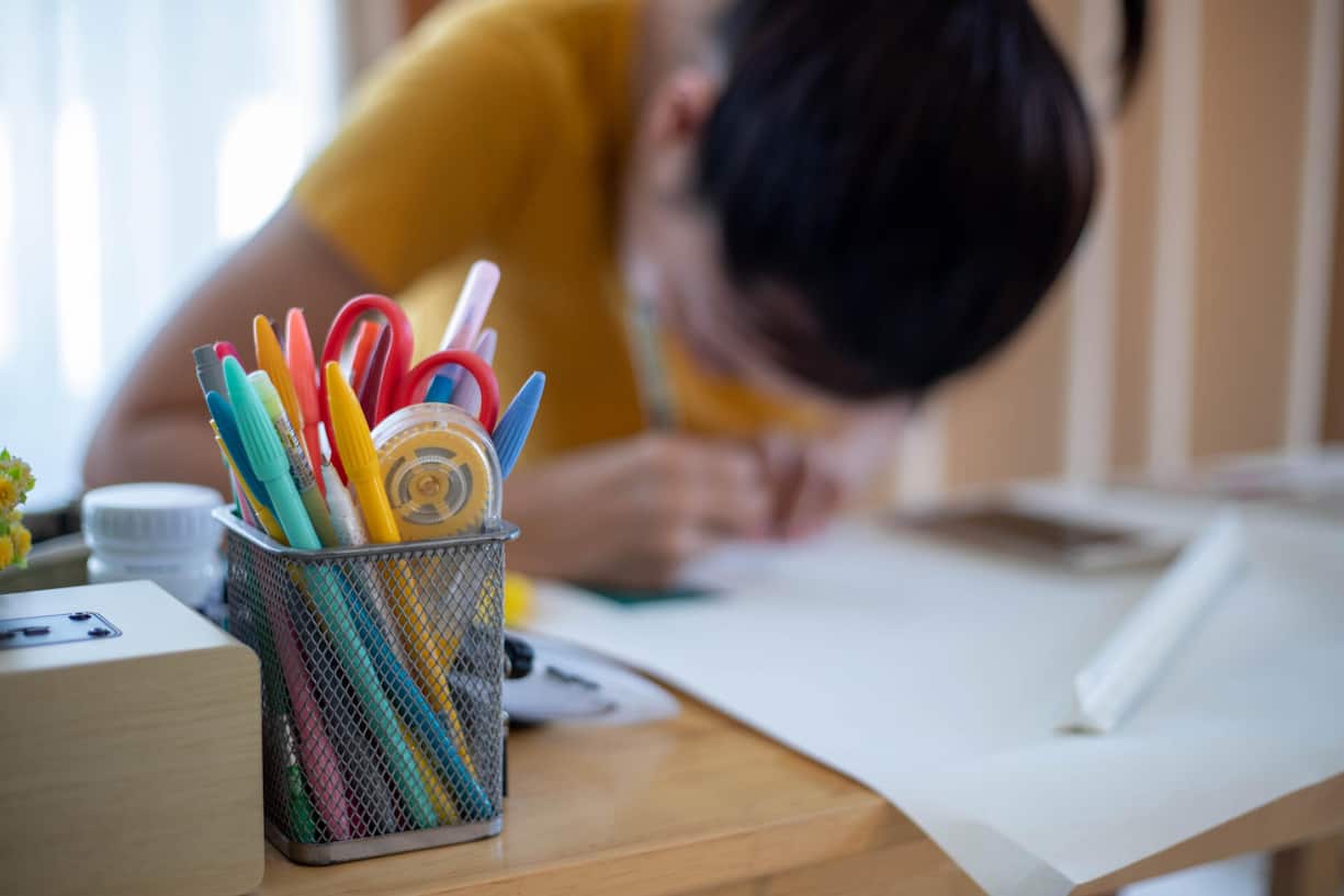 Cropped image of designer cutting paper for scrapbooking greeting postcards