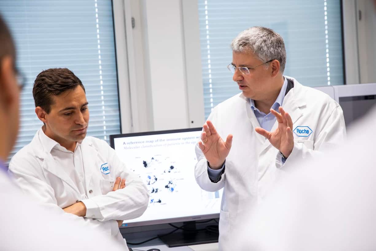 Roche-CEO Severin Schwan unterhält sich mit einem Mitarbeiter der Forschung.