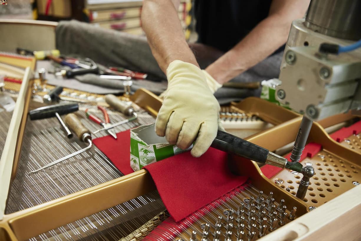 <p>Über 230 Saiten, darunter die über Kreuz gespannten Basssaiten, werden von Hand aufgezogen.</p>