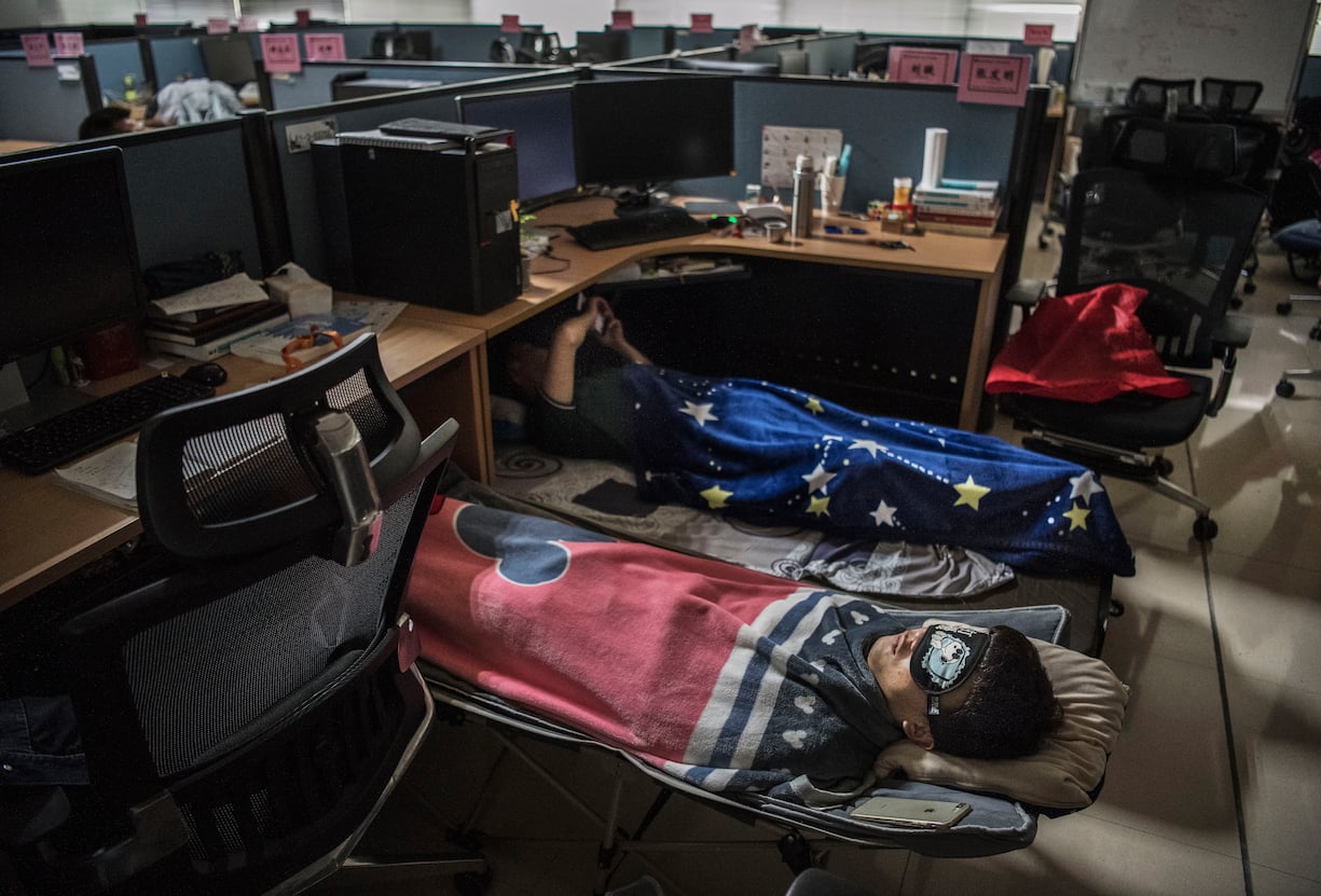 Huawei employees sleep at their cubicle during their lunch break, which is known to be common practice in many workplaces in China, at the research and development area in the Bantian campus on April 12, 2019, in Shenzhen, China.