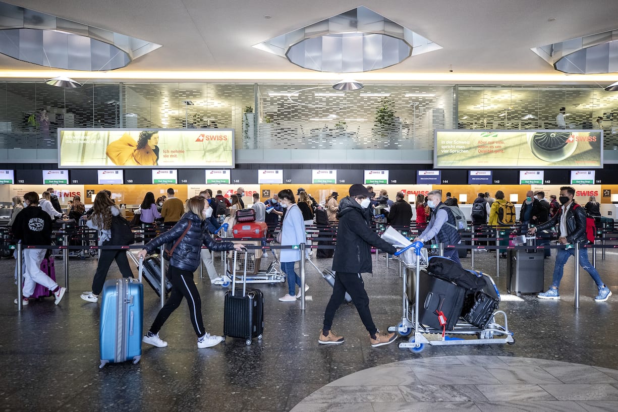Menschen stehen am Check-In Schalter der Fluggesellschaft Swiss am Flughafen Zuerich, fotografiert am Donnerstag, 1. April 2021. (KEYSTONE/Alexandra Wey)