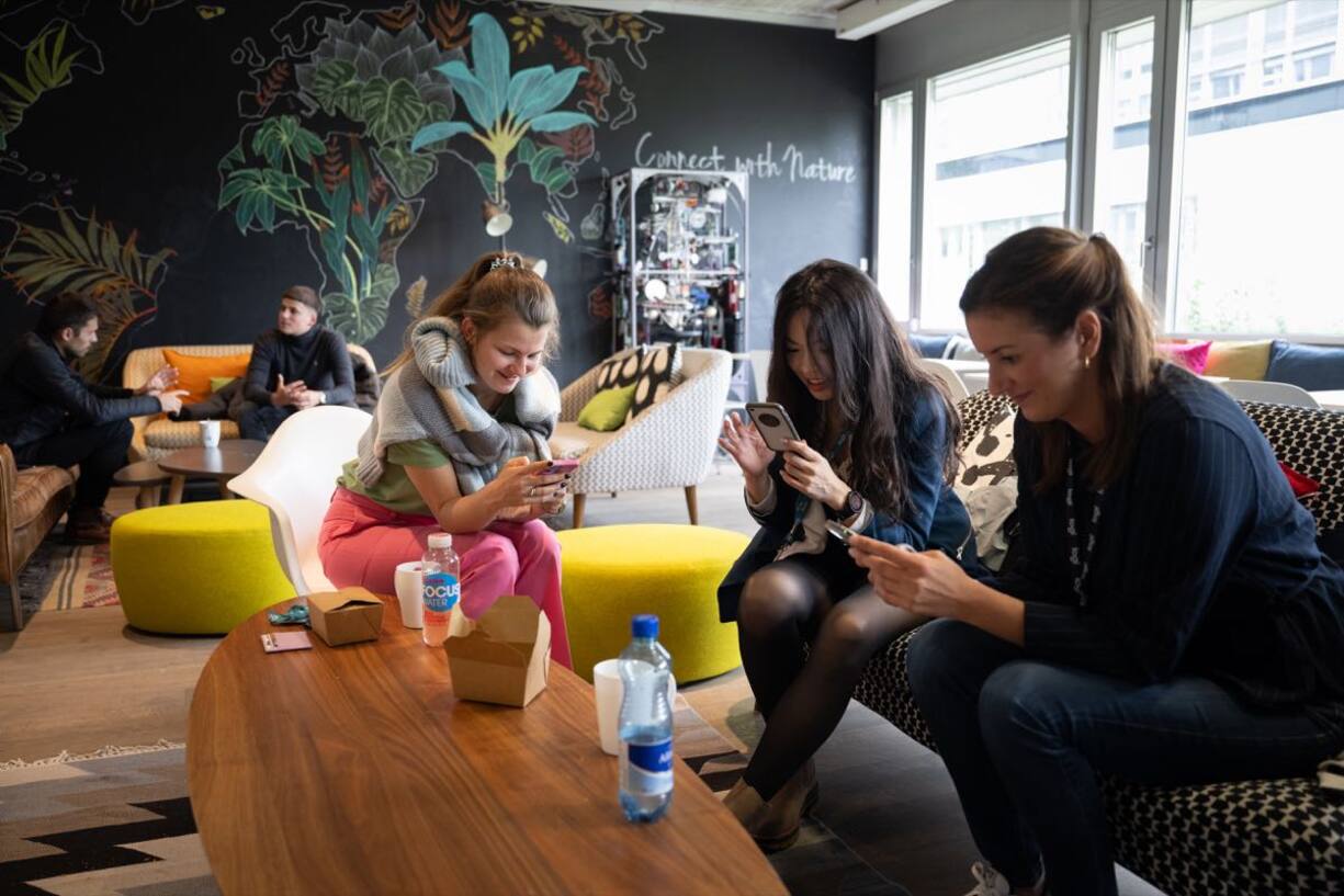 Drei Frauen sitzen an einem Tisch und besprechen neue Produktentwürfe am Logitech-Hauptsitz in Lausanne.