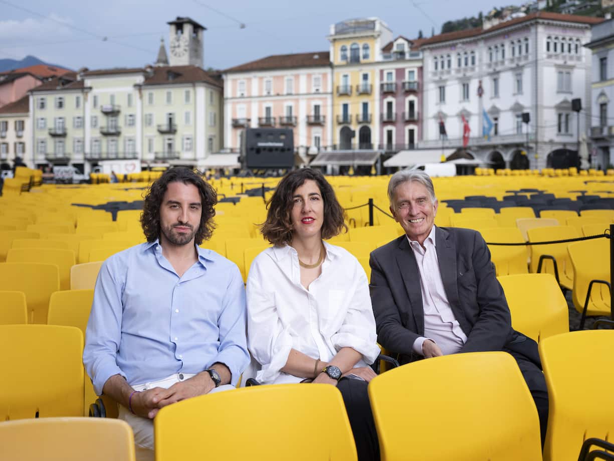 Raphael Brunschwig, Chief Operating Officer, Lili Hinstin, Artistic Director, and Marco Solari, President of the Locarno Film Festival, from left to right, pose for a photograph on the Piazza Grande in Locarno, Switzerland, on August 5, 2019. (KEYSTONE/Christian Beutler)