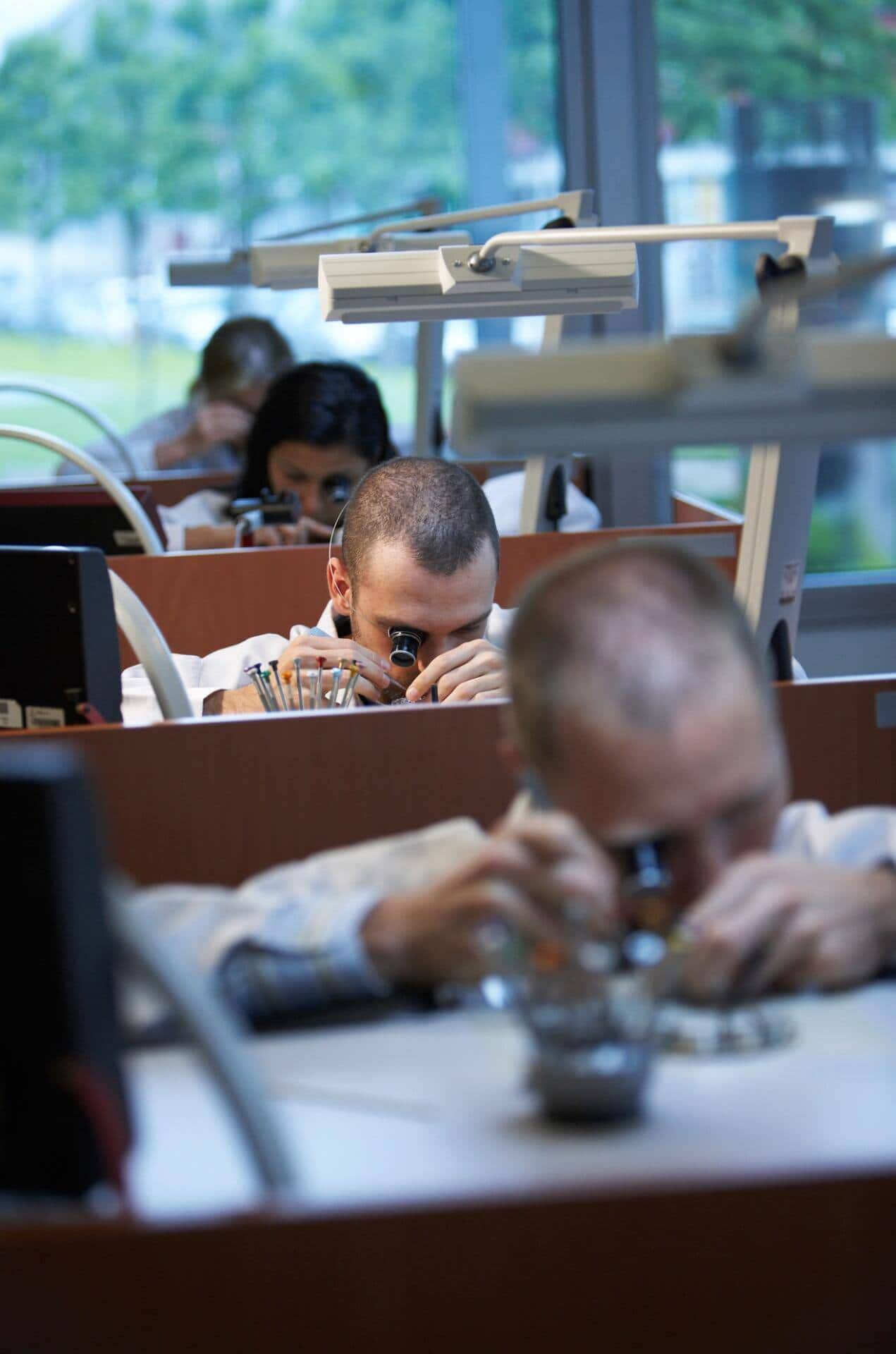 Uhrmacherinnen und Uhrmacher im Atelier.