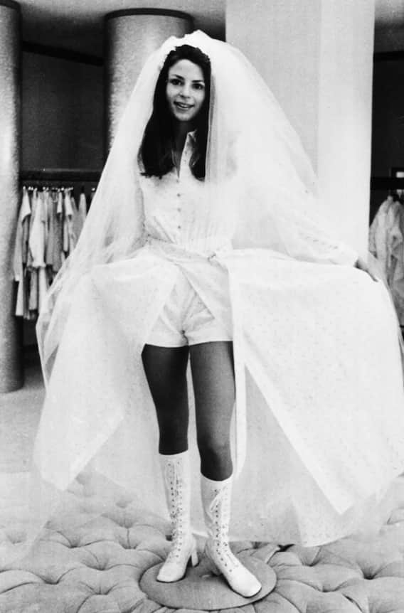 70er Jahre: Die verrückten 70er. Der Hippie-Boho-Chic-Stil umfasste lockere Silhouetten, Haarbänder und viele Blumendekorationen. Und ja, auch zur Hochzeit trugen Frauen in den 70er Jahren gelegentlich Hosen, besonders wenn sie einen ­informelleren oder alternativen Stil bevorzugten.