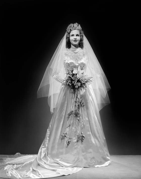40er Jahre: Schlichte Eleganz, klassische Silhouetten und sparsame Verzierungen prägten die Brautmode der 40er Jahre. Denn der Zweite Weltkrieg liess kaum Platz für Luxus und Glamour. Wer konnte, lieh sich ein Kleid oder nähte es selber. Kurze ­Längen waren sehr üblich.