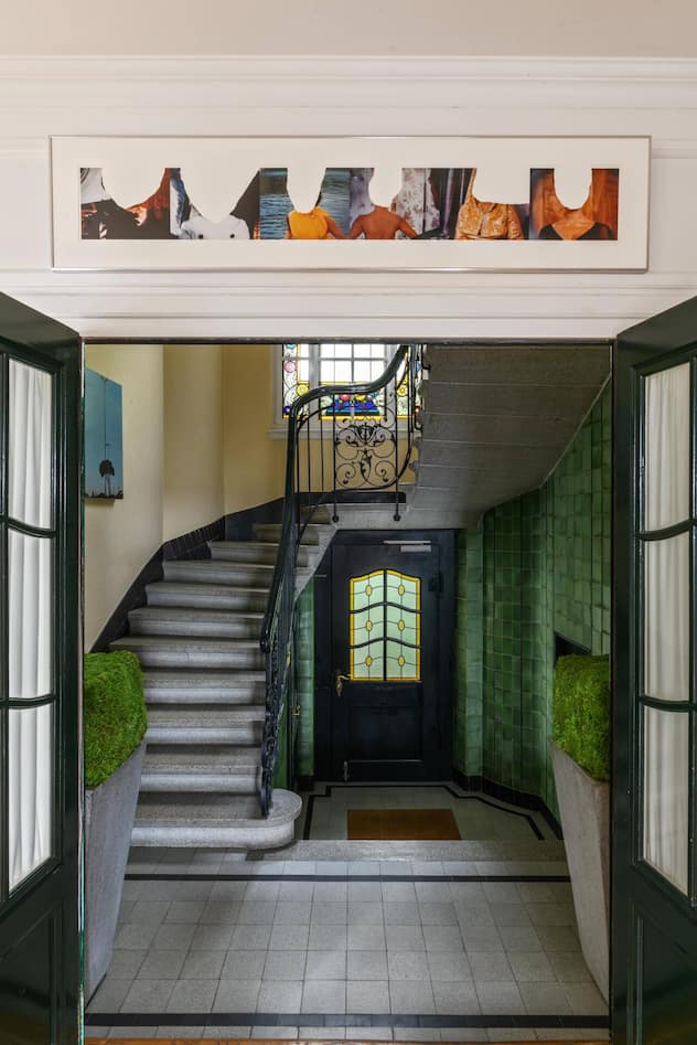 Der Eingangsbereich und der Treppenaufgang der Villa sind noch im Originalzustand erhalten. Sabine Parenti nahm die Grüntöne der Ornamente auf und platzierte passende Topfpflanzen.