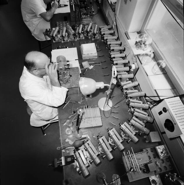 Ein Mitarbeiter der Firma Wild Heerbrugg AG, Hersteller optischer Vermessungsinstrumente, Labor- und Stereo-Mikroskopen, Reisszeugen und Instrumenten fuer die Photogrammetrie, aufgenommen im Kanton St.Gallen am 9. November 1960. Mittels dem Thedoliten T2 wird hier ein Fernziel eingemessen, um nachher die Nivelliere NK2 zu justieren. (KEYSTONE/PHOTOPRESS-ARCHIV/Vogt)