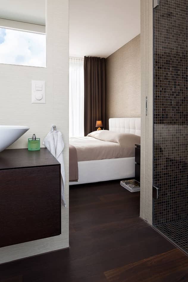 Für den Masterbedroom und das anschliessende Bad wählten die Bauherren eine helle Tapete, für die Dusche Bisazza-Mosaik.
