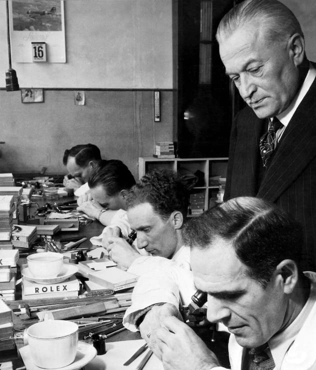 <p>Rolex-Gründer Hans Wilsdorf schaut seinen Uhrenmachern über die Schultern.</p>