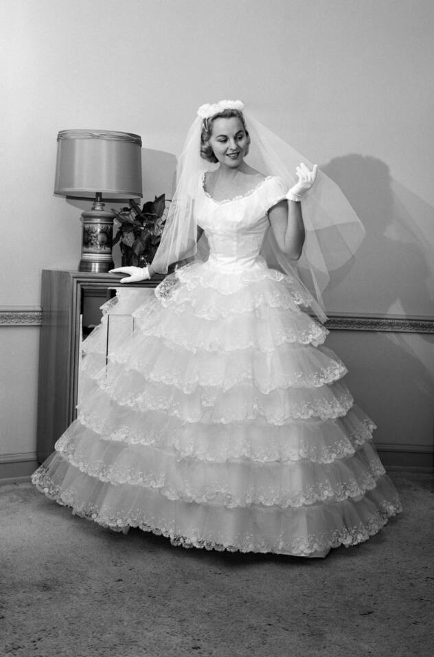 50er Jahre: In den 50er Jahren kam die Rückkehr zur Opulenz nach dem Krieg. Glamour und Fülle bildeten das Leitmotiv, die Taille war betont, die ­Röcke weit, die Schleier voluminös und aufwendig ­verziert. Typisch ­waren auch Spitzenapplikationen.