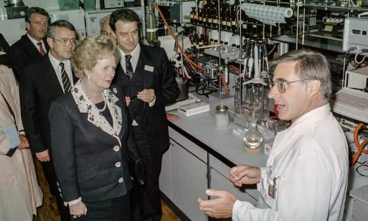 Der Chemiekonzern Ciba-Geigy war Mitglied im ersten SMI (im Bild ein Besuch der damaligen britischen Premierministerin Margaret Thatcher im Forschungslabor Basel). 1996 fusionierte Ciba mit der ebenfalls im SMI enthaltenen Sandoz zu Novartis.