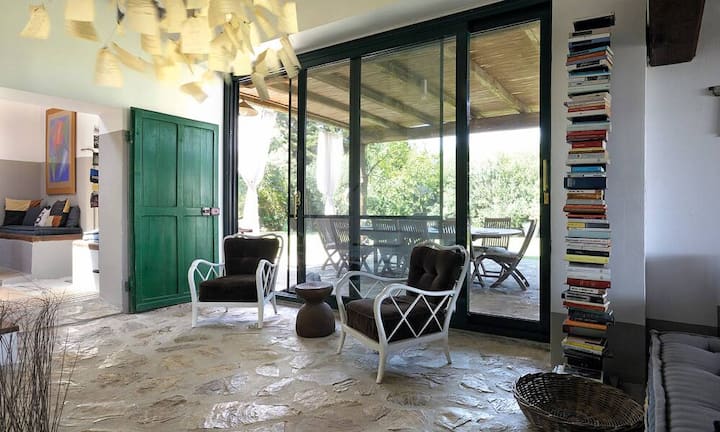 Aussenraum: Besonders viel Zeit verbringen die Bewohner auf der Terrasse, von dort geniessen sie den Blick ins Güne und zur Aussenküche. Die weissen Kunststoffmöbel stammen von Kartell.