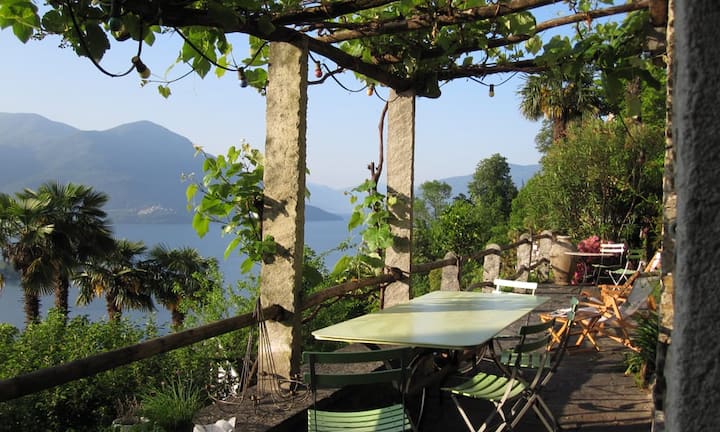 Die mit Trauben verwachsene Pergola spendet dem Sitzplatz angenehmen Schatten. Der alte Pflanzen- und Baumbestand im mediterranen Garten verleihen Authentizität.