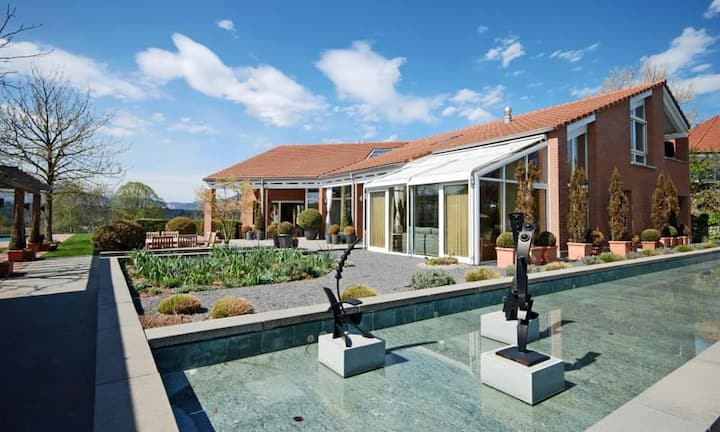 Das Bachsteingebäude mit Wintergarten ist umgeben von...