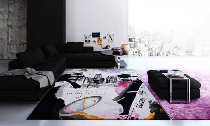 Kreativ: Der rechteckige Teppich kombiniert mit schwarzen Wohnzimmermöbel passt perfekt in die Grosstadt-Wohnung.