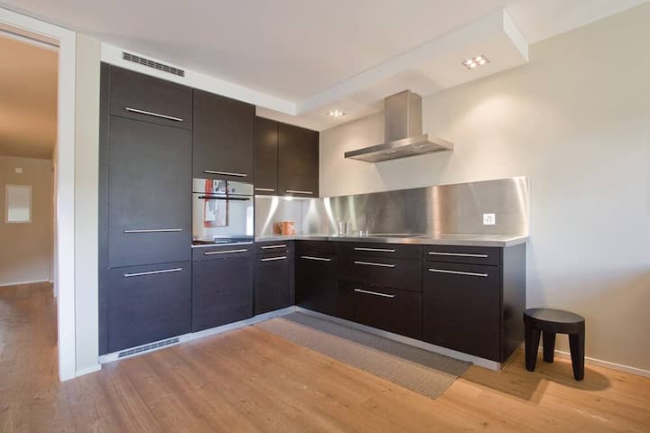 Die offene Wohnküche ist modern, aber dennoch dezent ausgestattet. Einkaufsmöglichkeiten befinden sich in der Nähe.