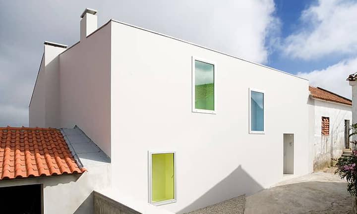 Das moderne Gebäude «Sobral da Lagoa» mit seinen farbigen Fenstern steht…