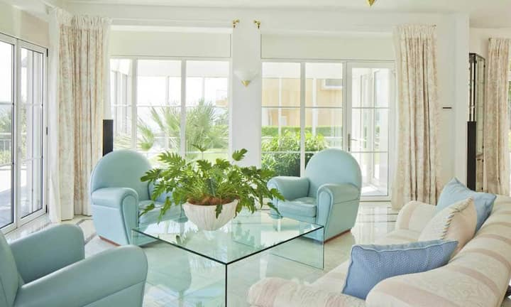 Über ein Eingangsportal gelangt man in die grossen Räume des Hauses. Das seitlich angelegte Treppenhaus ist mit farbigen Tiffanyfenstern ausgestattet und erschliesst die zwei Wohnebenen. Im offenen Wohnzimmer mit Essbereich und angrenzender Bibliothek, welche durch ein zweiseitig einsehbares Cheminée getrennt wird, kann man mit Seesicht entspannen.