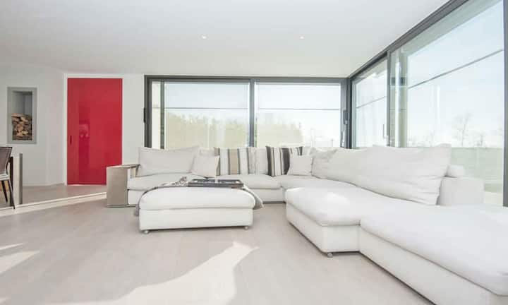 Der grossräumige Wohnbereich mit Kamin und grossen Fenstern ermöglicht eine angenehme Atmosphäre.