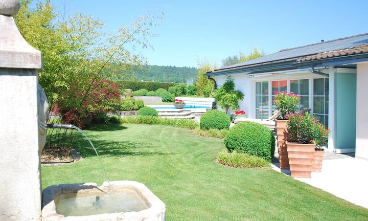 Der Wintergarten mit seinen vollversenkbaren Scheiben und offenem Kamin verbindet das Wohnhaus mit dem Garten.