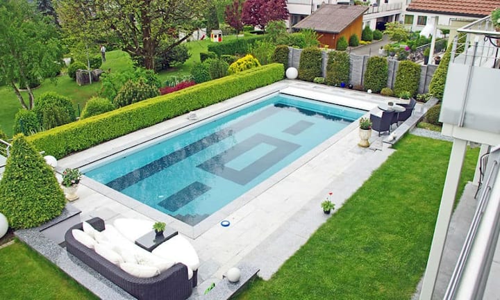 Ein beheiztes Aussenschwimmbad mit automatischer Abdeckung wird abends beleuchtet. Das Untergeschoss verfügt über einen 26 m2 belichteten, beheizten Fitnessraum.