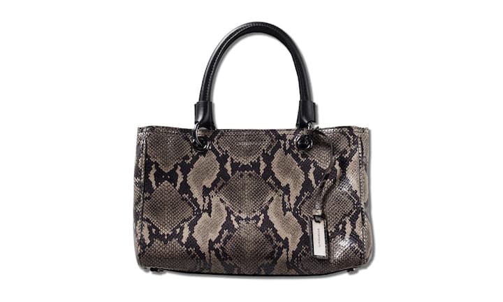 Exotisch: Strenesse Diese Tasche in Python-Print-Optik mit einer Henkelbefestigung aus glänzenden Ringen hat zwei Hauptfächer, sowie weitere kleine Fächer. Sie kann an den Henkeln oder mit dem ebenfalls abnehmbaren Riemen über der Schulter getragen werden. Preis 700 Franken Bilder: PR