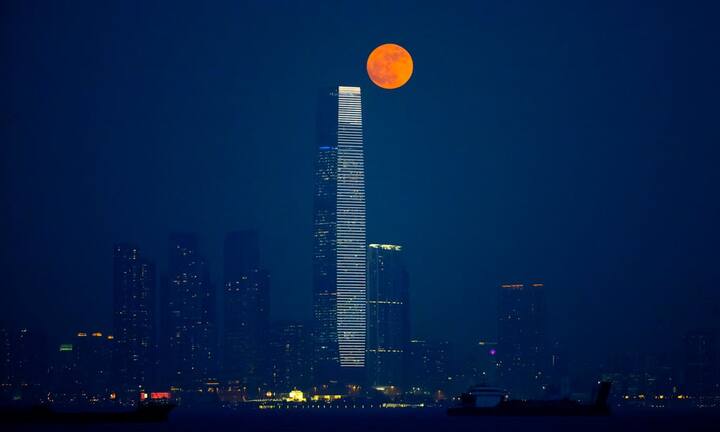 In Hongkong scheint der Mond an der Skyline zu kleben.