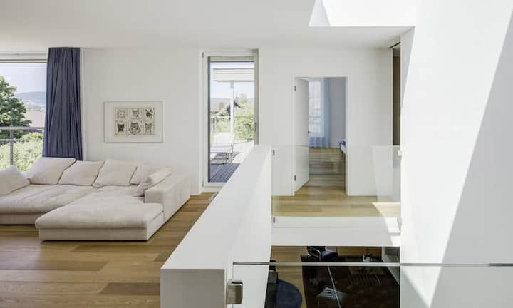 In der zweiten Etage gibt es ein grosses Familienzimmer, zwei geschlossene Zimmer, ein Bad mit Walk-in-Dusche sowie das Elternschlafzimmer mit Ankleide und Bad en Suite.