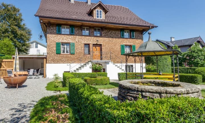 Das 1763 gebaute und über die Jahre umfassend sanierte Bauernhaus liegt in unmittelbarer Nähe des Dorfzentrums von Cham. Zu Fuss erreicht man mehrere Lebensmittelgeschäfte (Coop, Migros), die Post, Banken und verschiedene Restaurants.