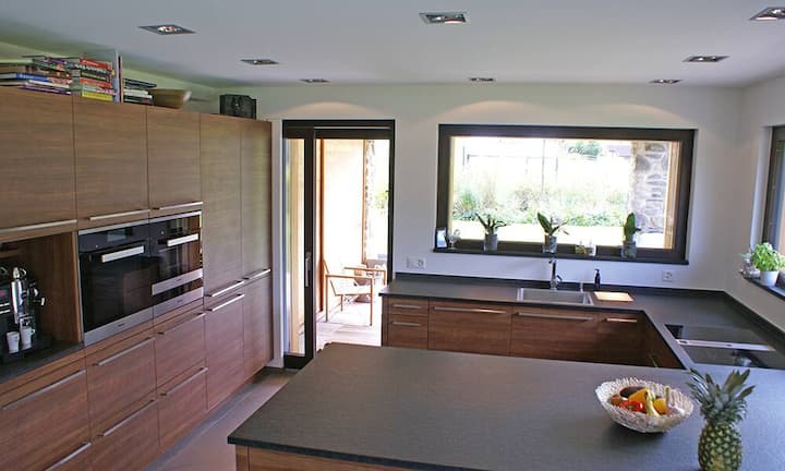 Die hochwertige, voll ausgestattete Küche und der grosszügige Essbereich mit Ausblick bilden eine Einheit.