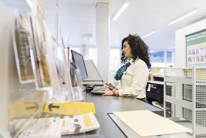 A retail trade apprentice of the Swiss Post works at a computer at the post office Basel 3 Spalen, Switzerland, on January 18, 2016. (KEYSTONE/Christian Beutler)